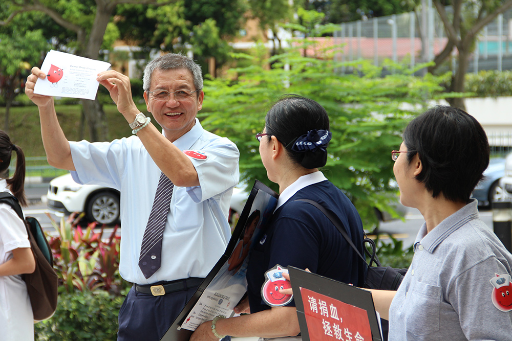 Since 2009, Mr. Sim Hee Chew had been joining his wife, Madam Chua Ah Suai in community blood donation activities by taking on roles in the lead group and encouraging passers-by to donate blood to save lives. The scope of volunteering work by Mr. Sim spanned across various fields. (Photo by Lee Foo Tien)