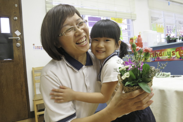 Huang Yu Xuan presents her basket of flowers to instructor Chen Li Hua. Photo by Li Xiao Ting