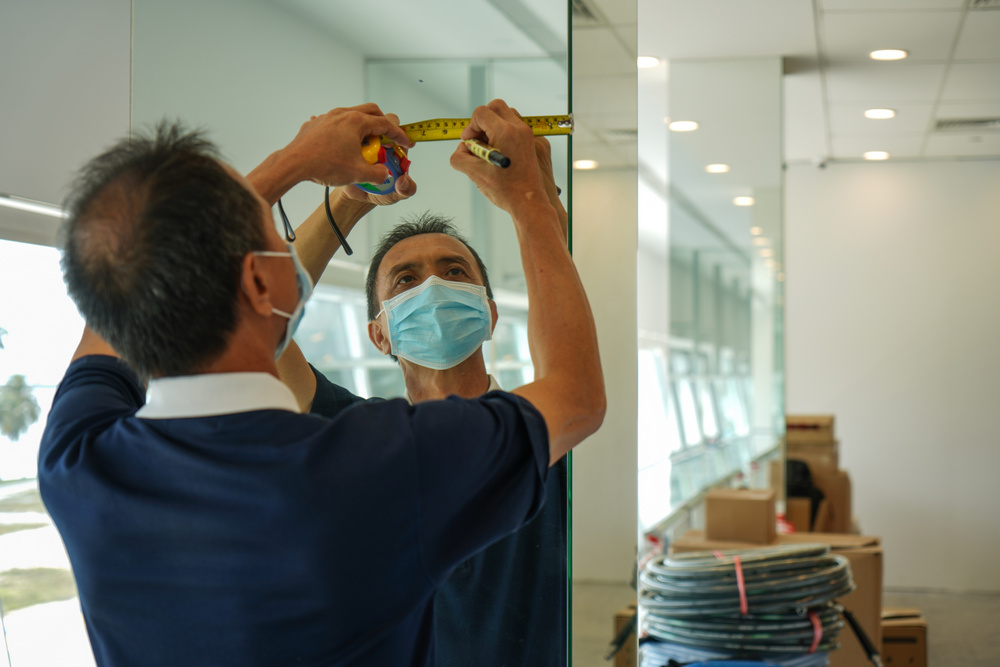 A volunteer going to great lengths to ensure accurate alignment before putting up the posters. (Photo by Chan May Ching)